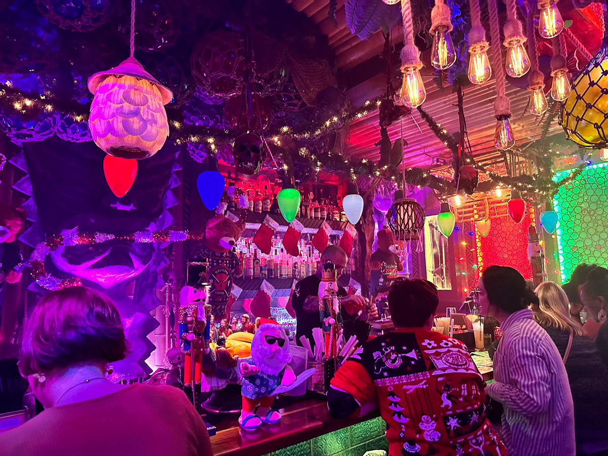 bar with tiki theming and bright blue and pink lighting